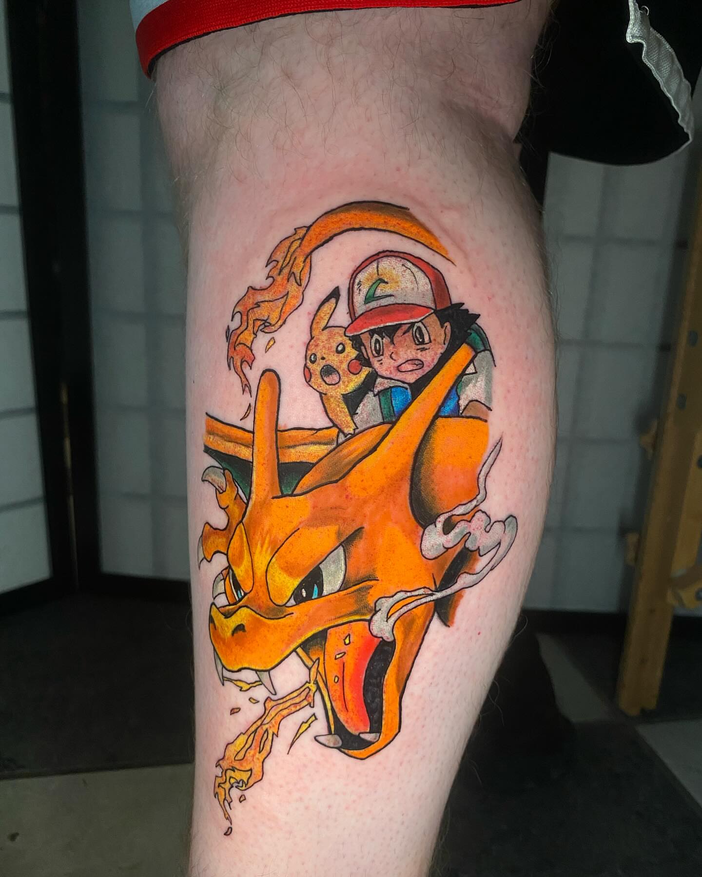 Dragon and trainer anime tattoo on the thigh by Glen Wallis