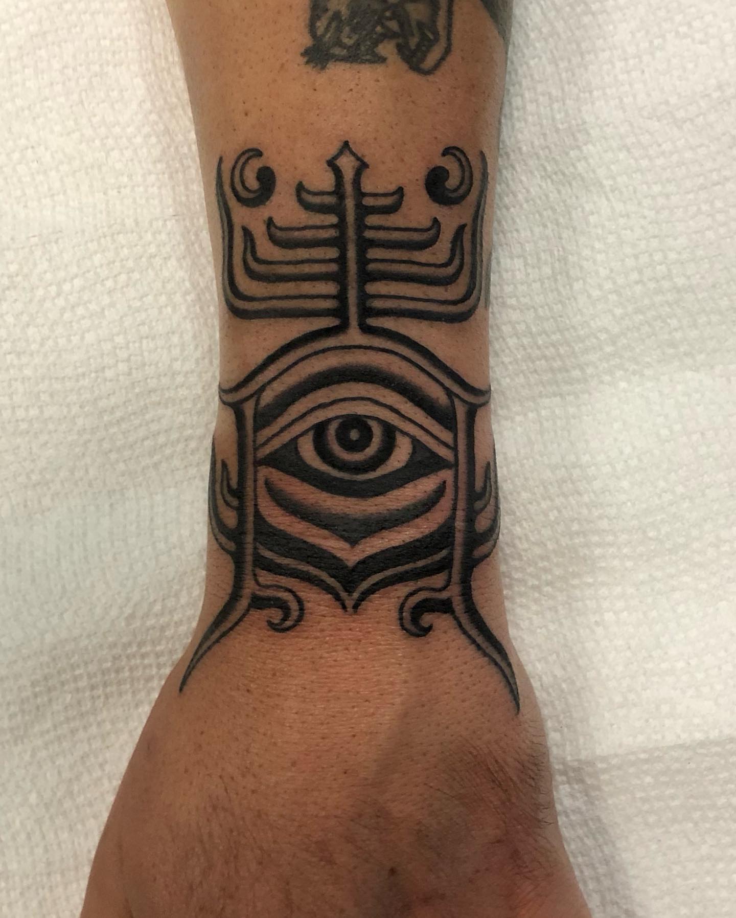 Eye with tribal design tribal tattoo on the forearm by Ben Fiedler