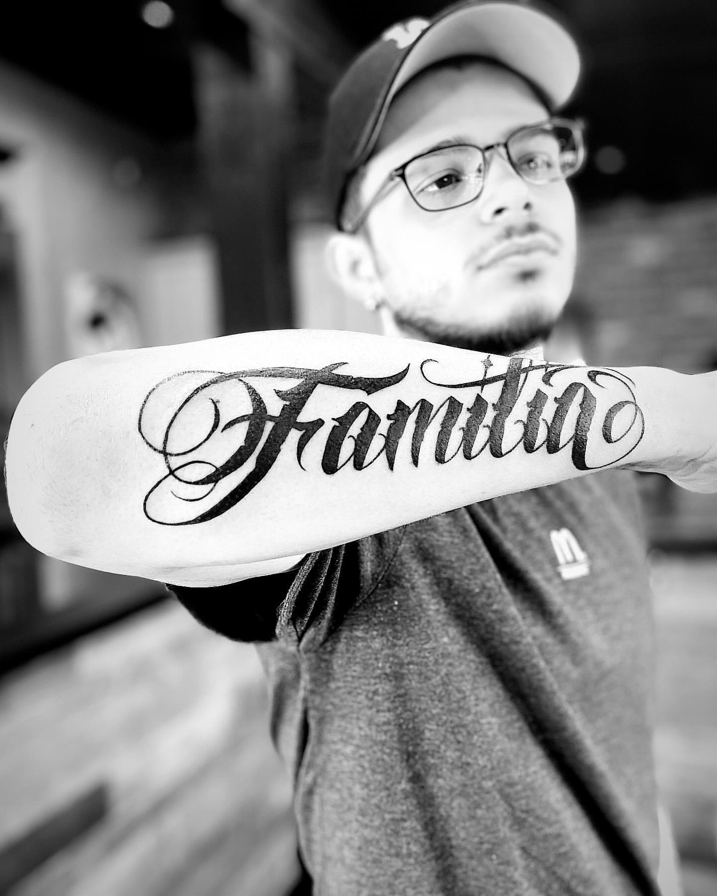 Familia lettering script tattoo on the forearm by Brian Keith