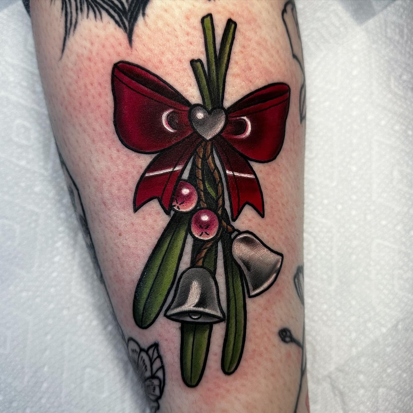 Mistletoe and bells American traditional tattoo on the forearm by ✨Sarah Knapp✨, Eugene, Oregon