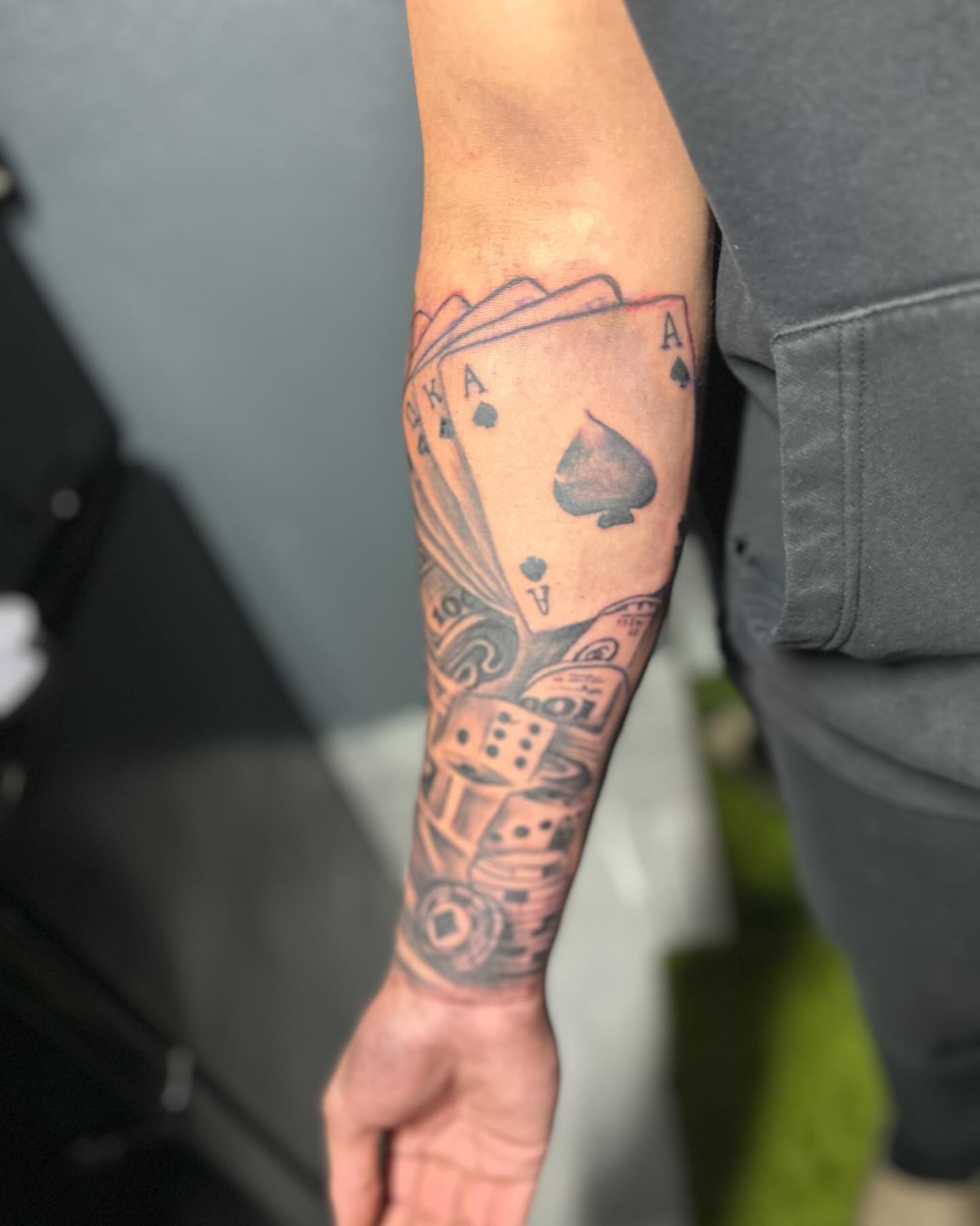 Playing cards black and grey tattoo on the forearm by DC