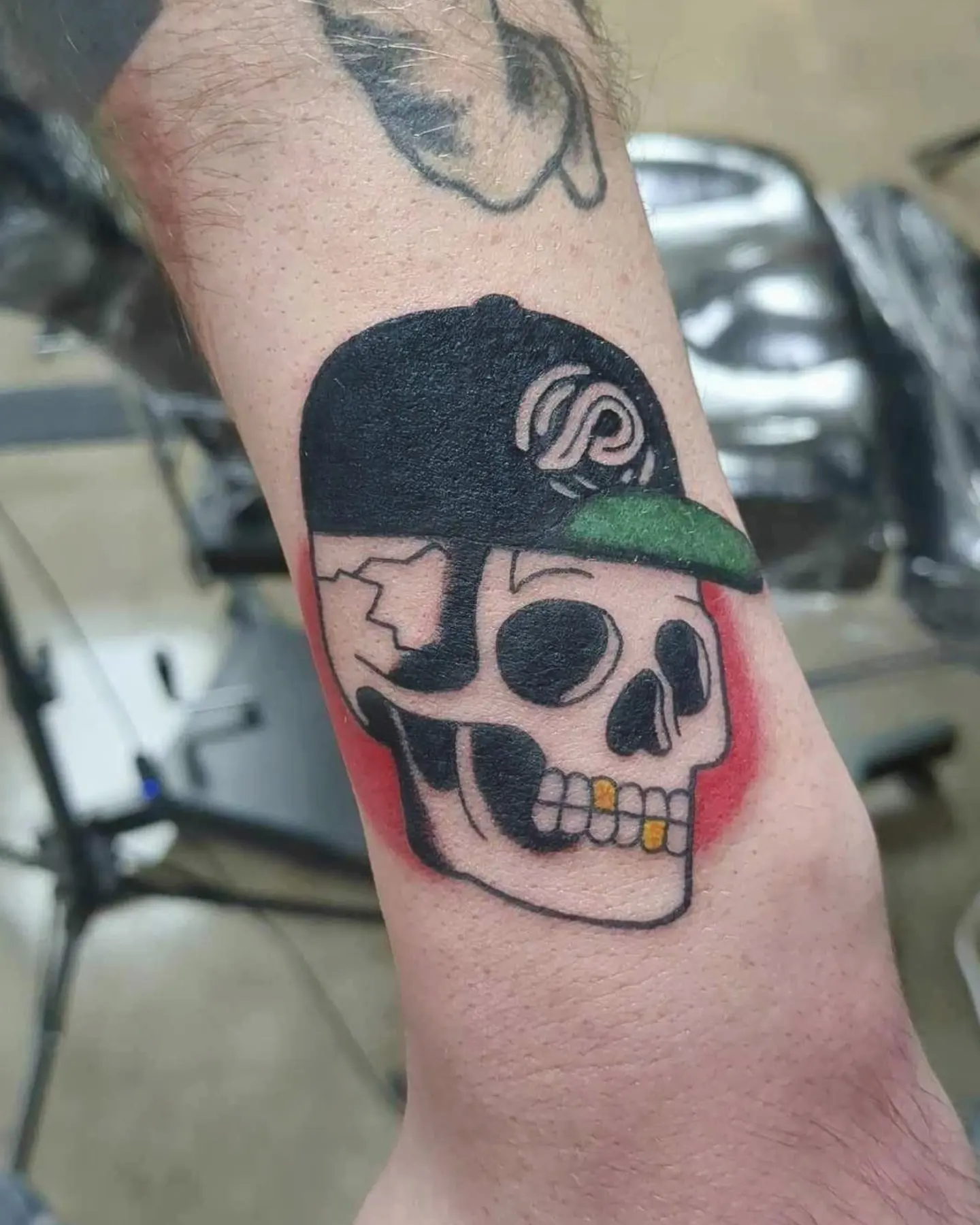 Skull wearing cap realism tattoo on the forearm by Seth Chitwood
