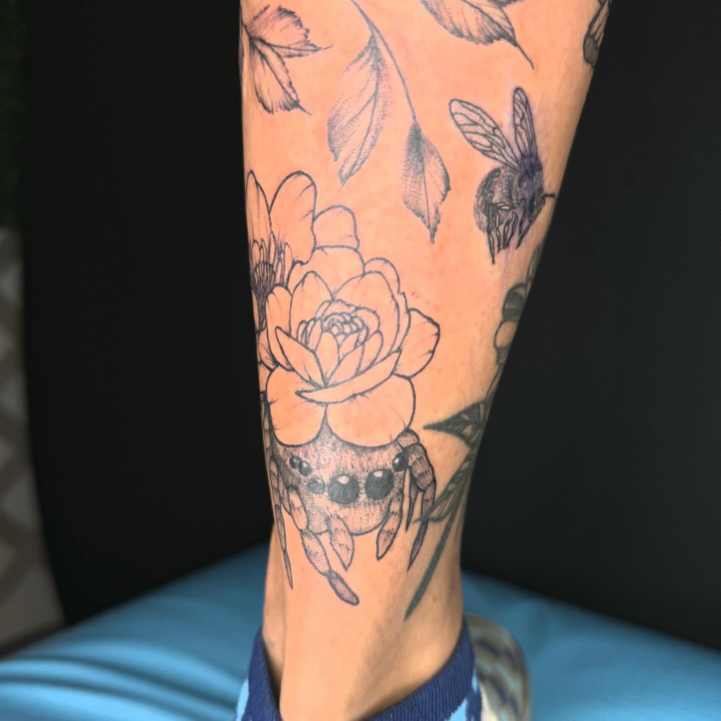 Lotus flower and bee black and grey tattoo on the forearm by @inkedbybanti