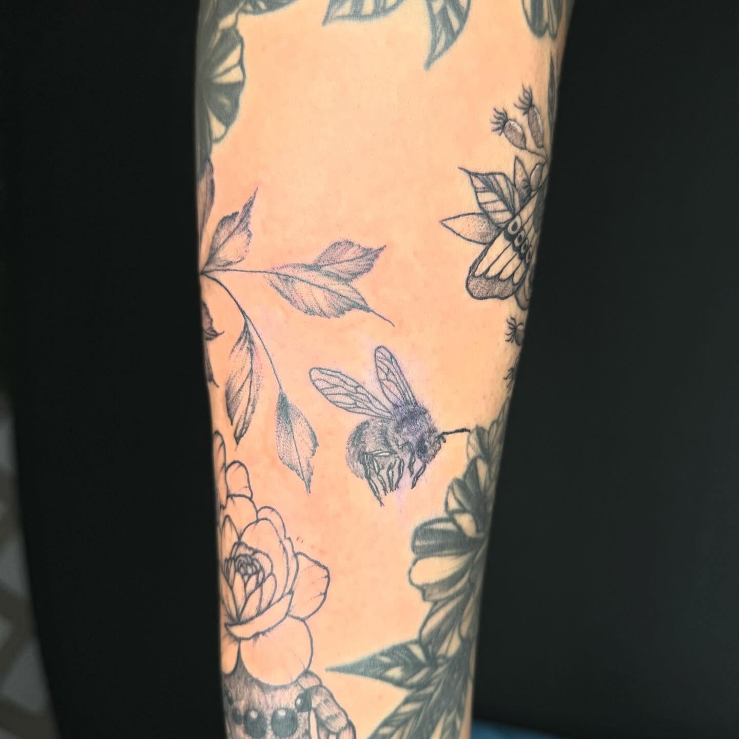Bee and floral black and grey tattoo on the forearm by @inkedbybanti