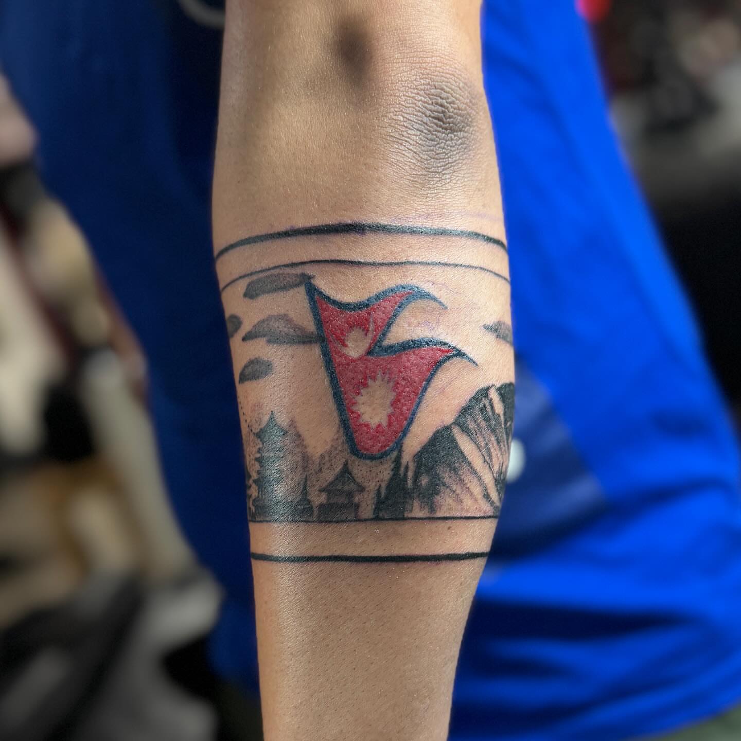 Nepali flag neo-traditional tattoo on the forearm by Steve