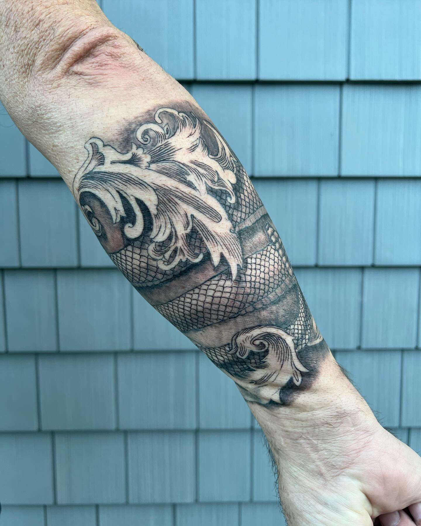 Koi fish black and grey tattoo on the forearm by Iconic Ink, Millbury, Massachusetts