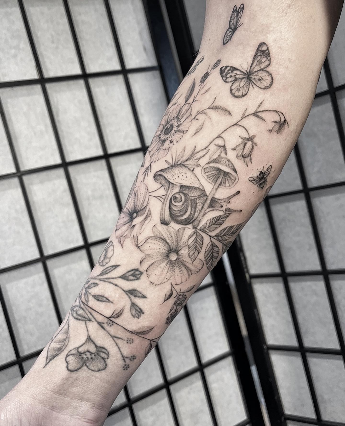 Floral and insect realism tattoo on the forearm by Tattoo Yulia Kononenko