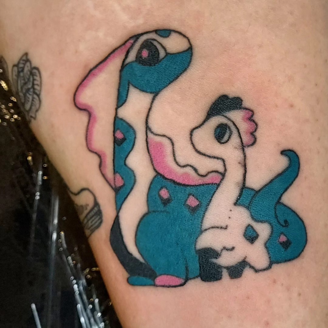Dinosaur family dotwork tattoo on the thigh by Spike Cameron