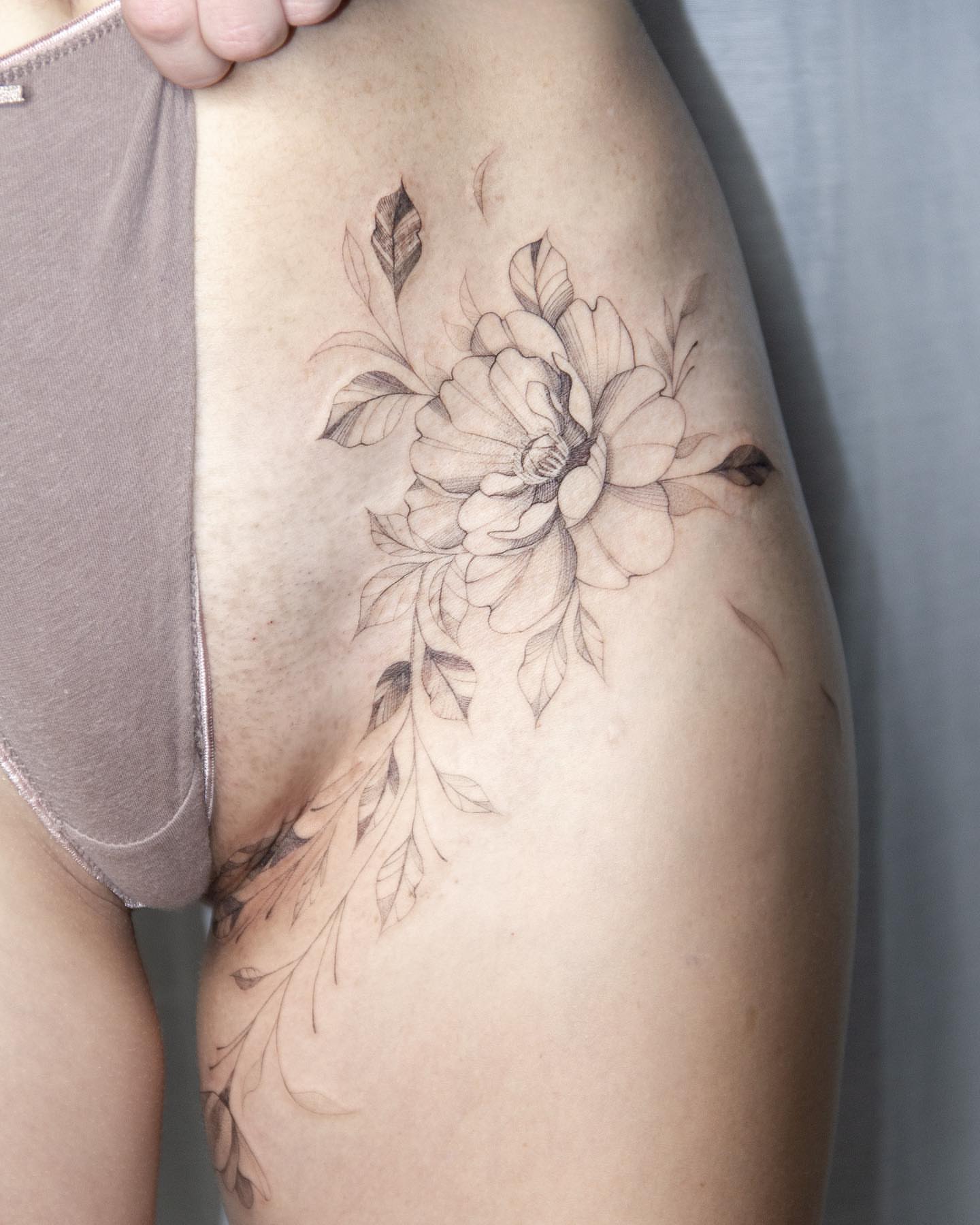 Flower black and grey tattoo on the thigh by Liv