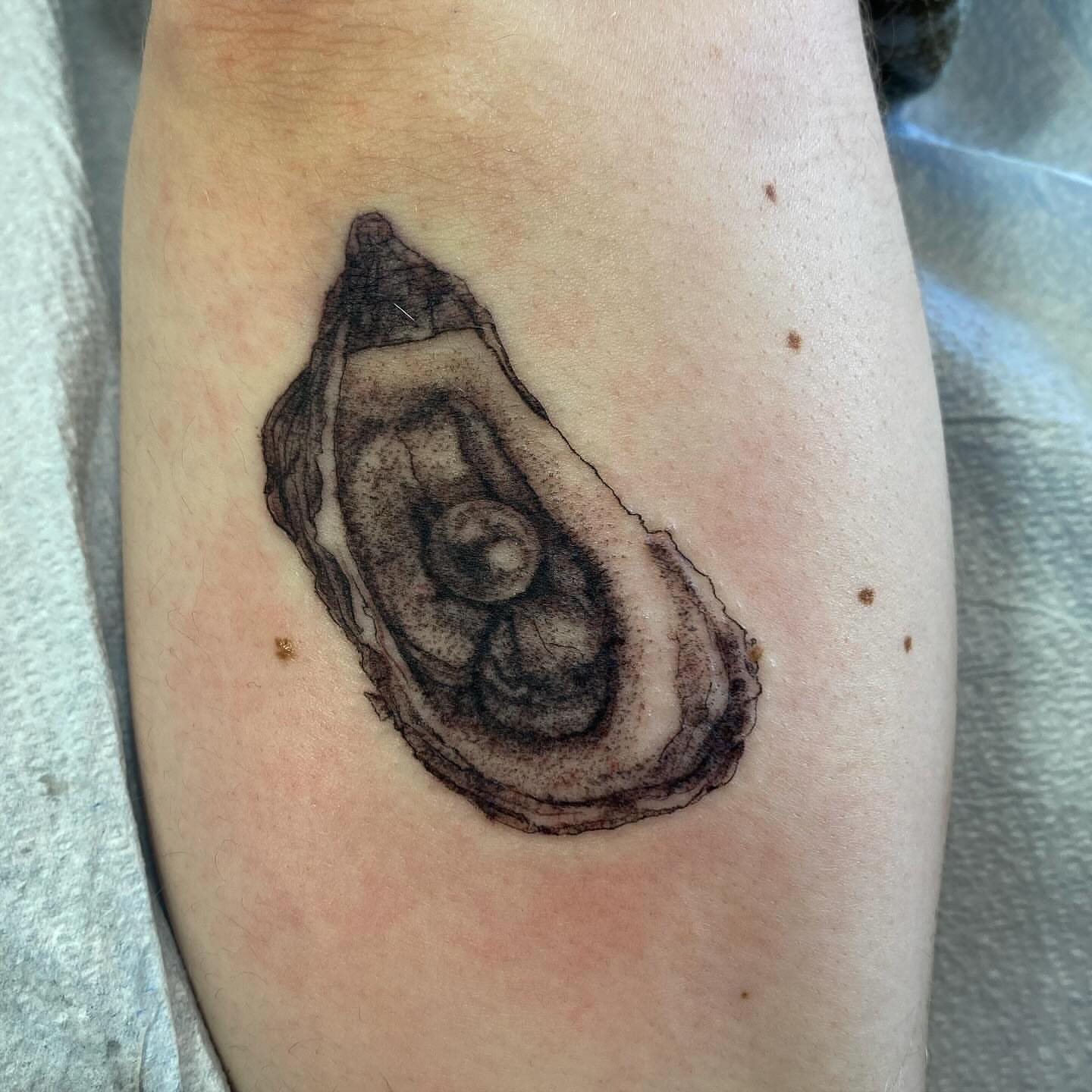 Oyster shell black and grey tattoo on the forearm by Joey Delarosa, San Francisco, California