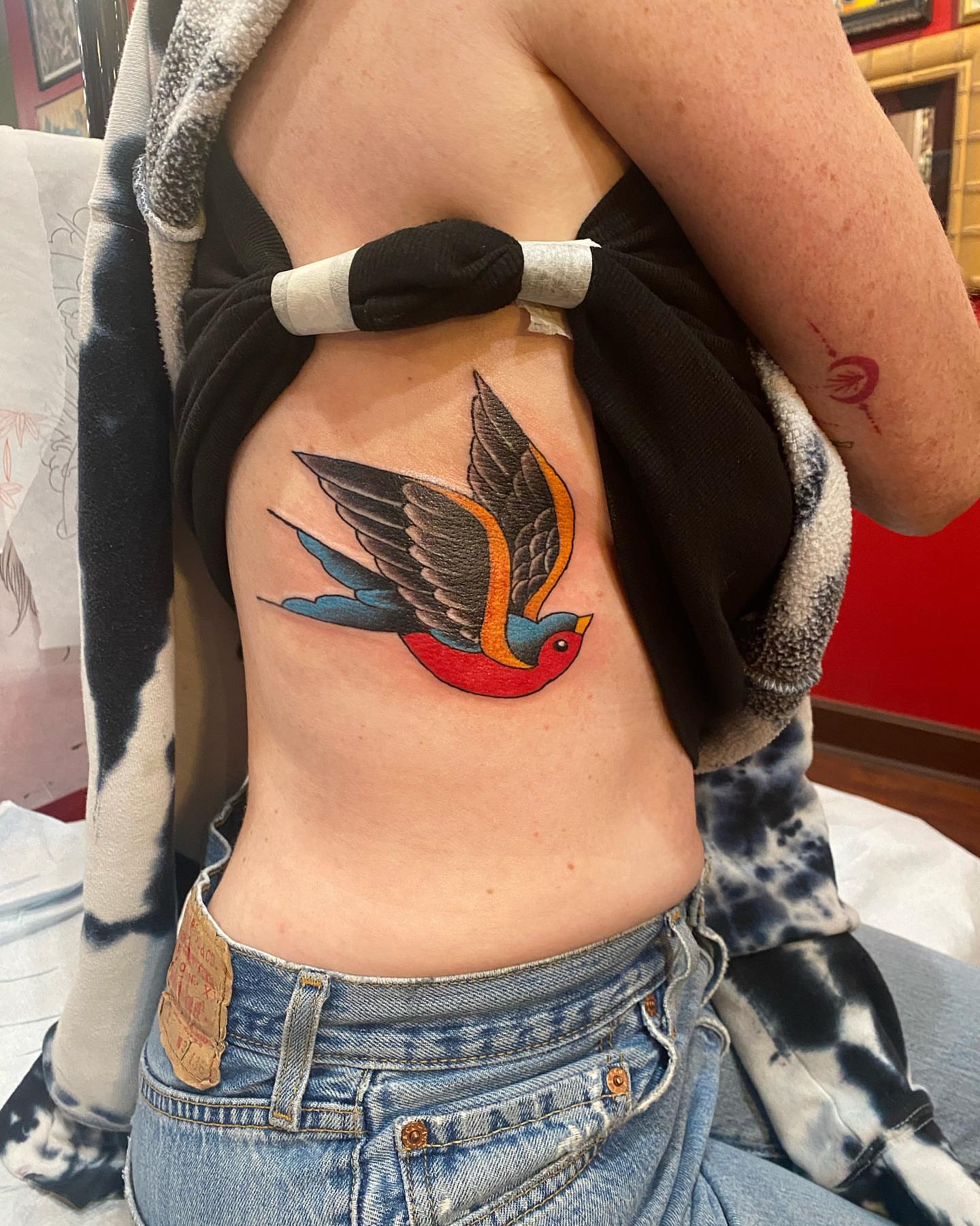 Swallow American traditional tattoo on the ribs by Christopher Sanders