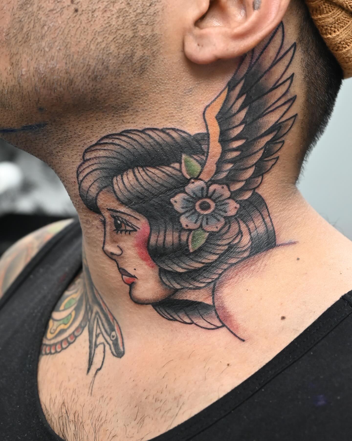 Woman's head with wings American traditional tattoo on the neck by Neri Gersaint