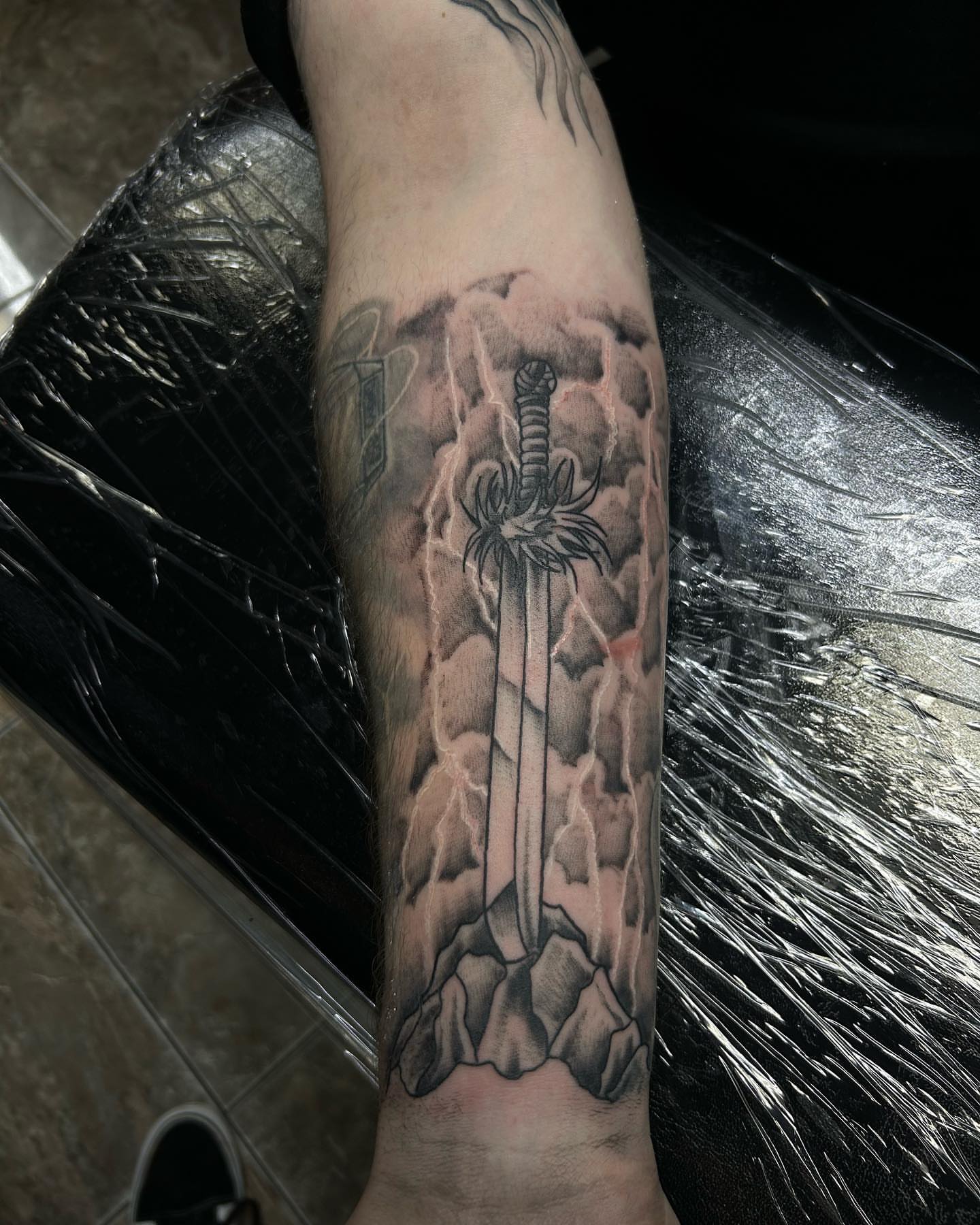 Lightning and sword realism tattoo on the forearm by Ares Rhodes