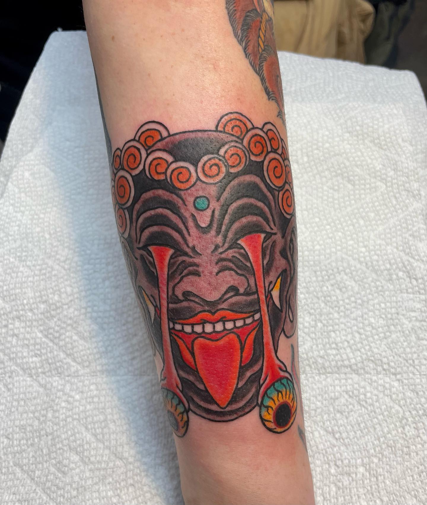 Clown mask American traditional tattoo on the forearm by Seth Griffin