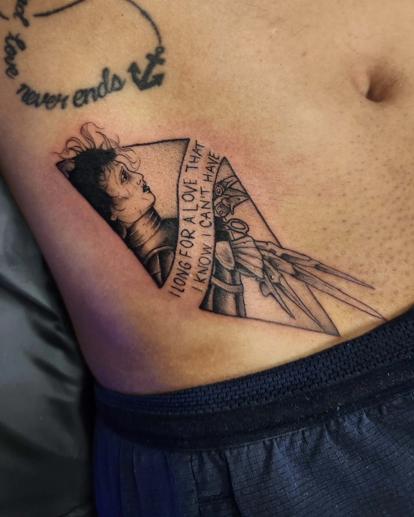 Longing for love black and grey tattoo on the ribs by Adrian Chavez