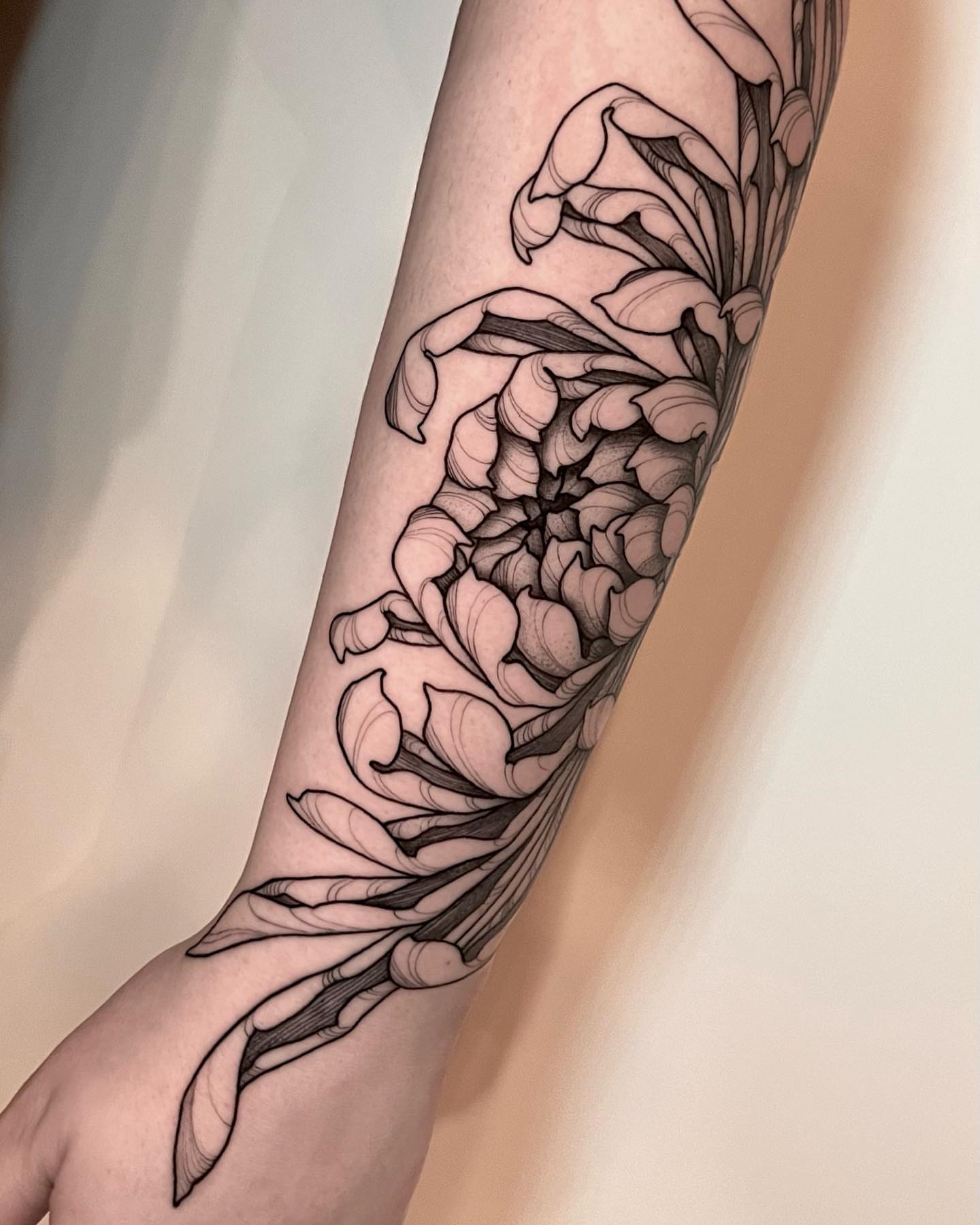 Floral design black and grey tattoo on the forearm by Chelsea Darling