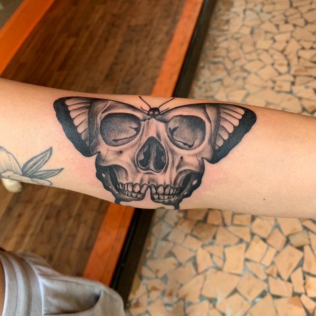 Skull and butterfly realism tattoo on the forearm by Brad Sterling