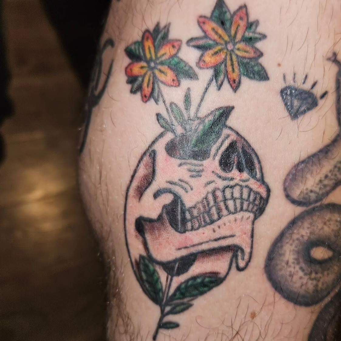 Skull with flowers American traditional tattoo on the thigh by zion