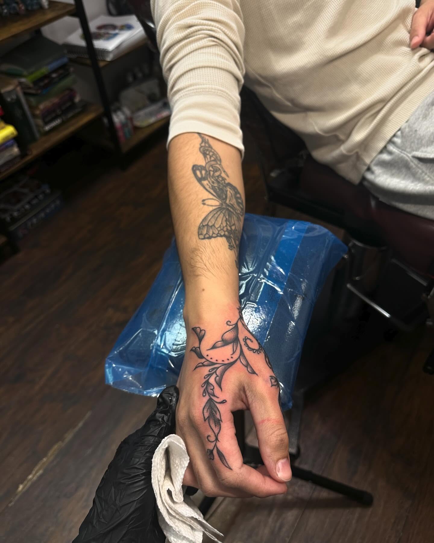 Butterfly and vine black and grey tattoo on the forearm by Kassie Perian