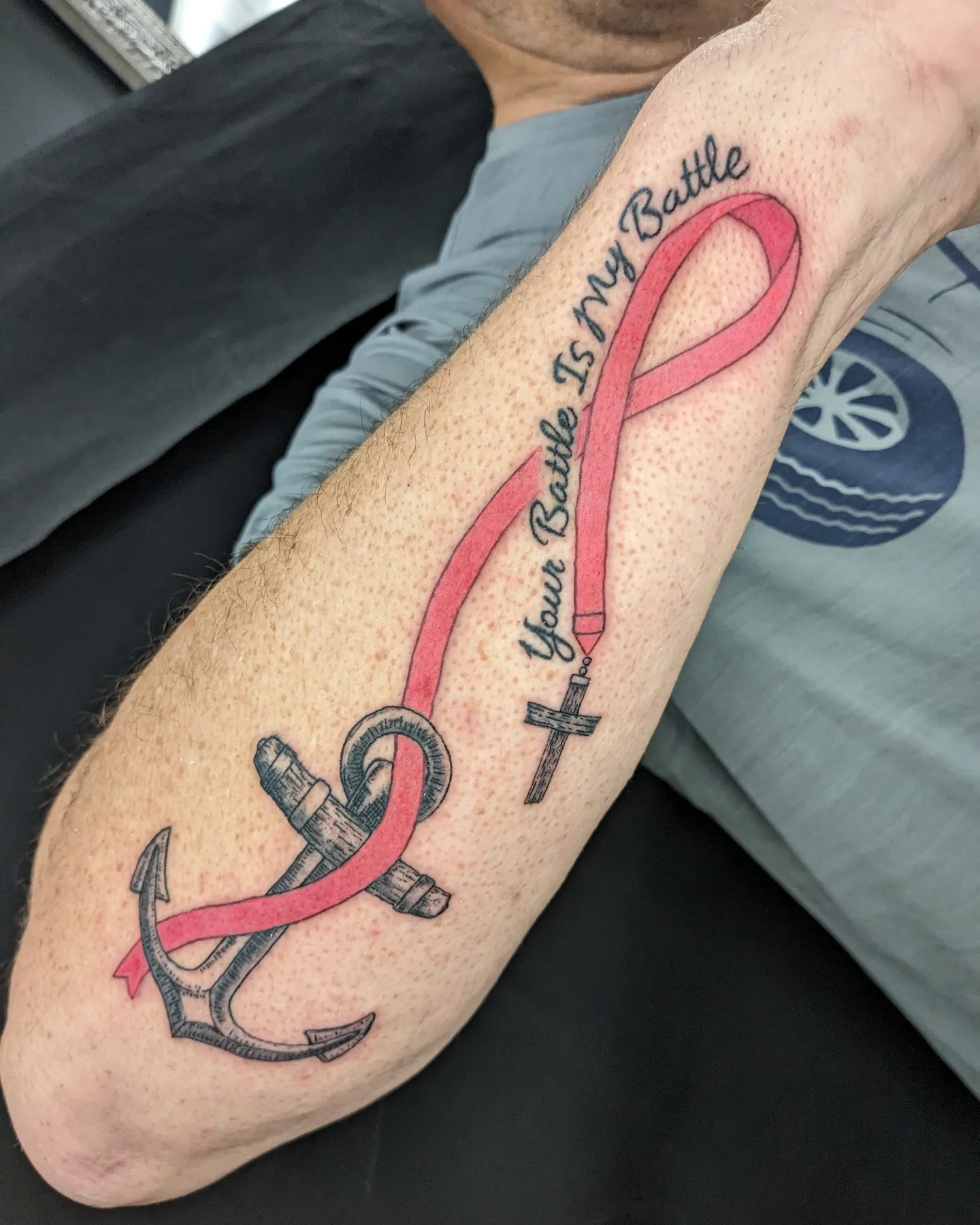 Breast cancer awareness ribbon neo-traditional tattoo on the forearm by Seth Chitwood