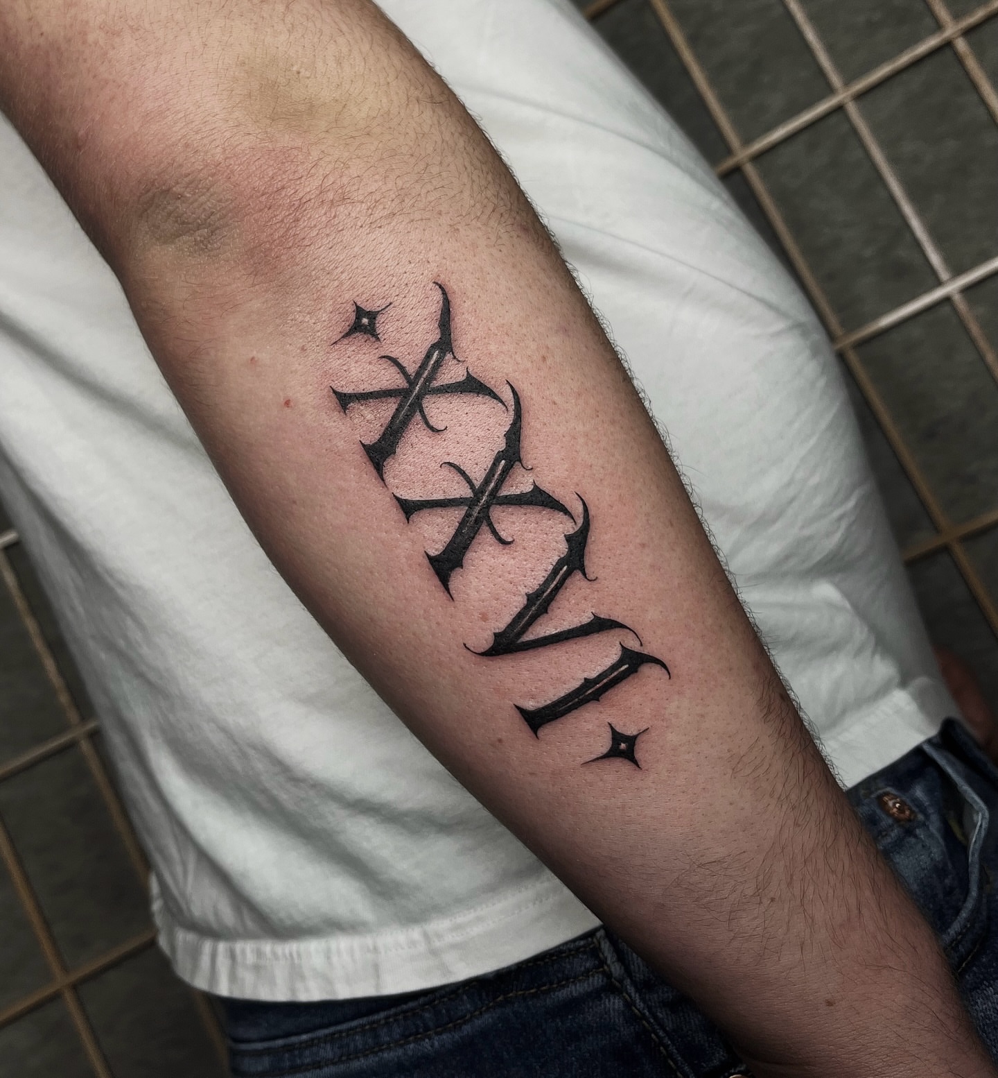 Roman numerals black and grey tattoo on the forearm by Taylor Newton