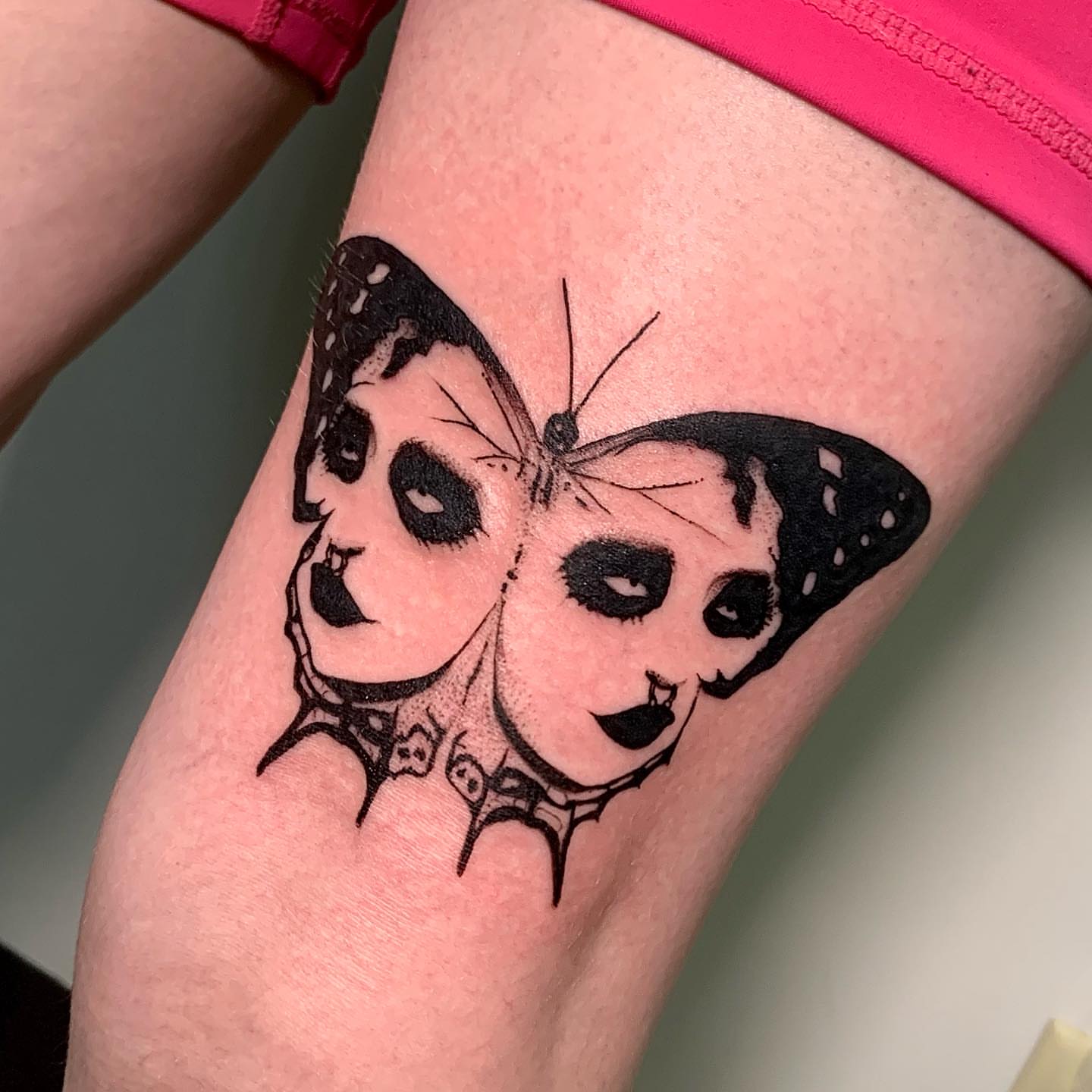 Butterfly with panda faces realism tattoo on the thigh by Maddy Paige