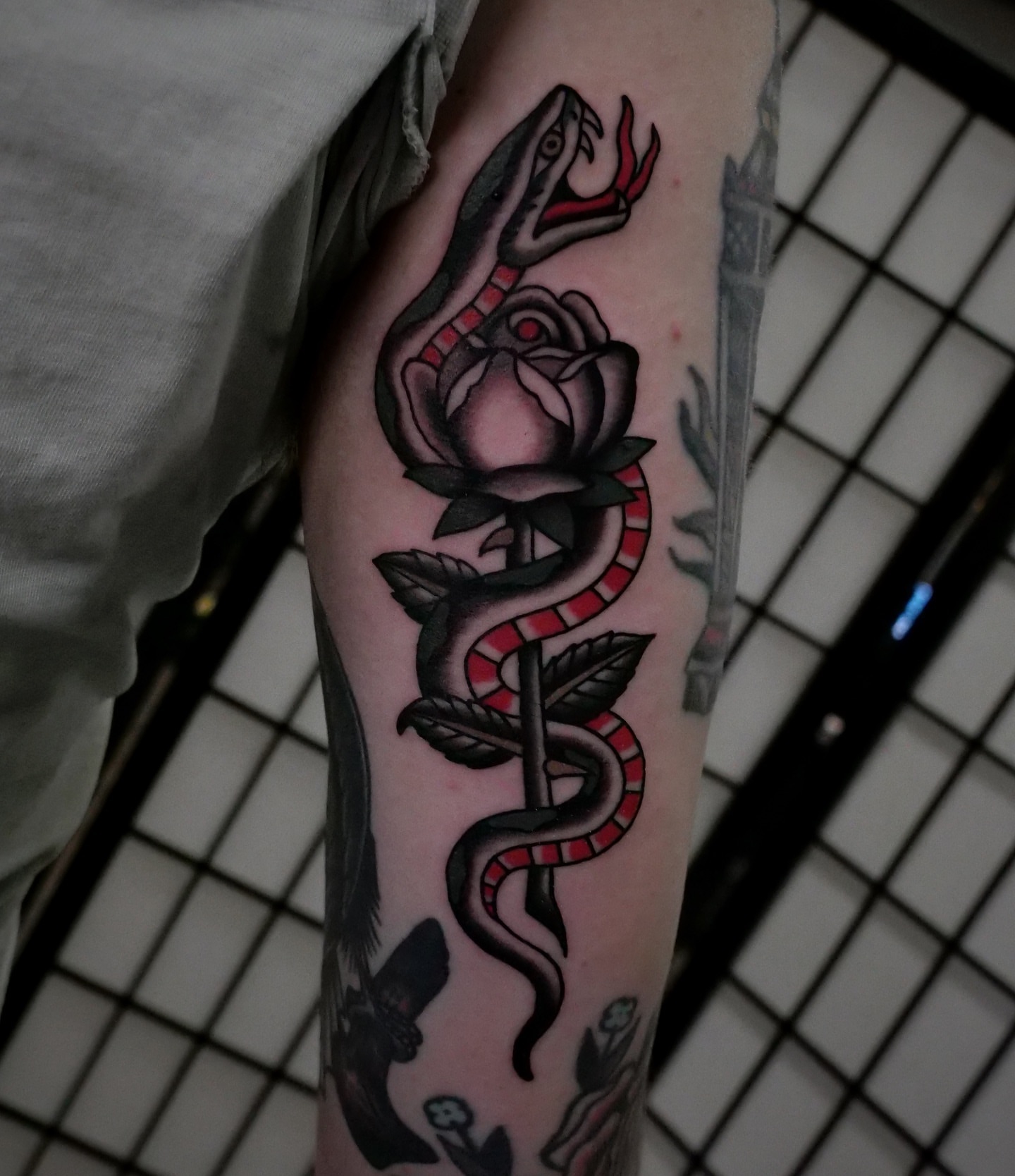 Snake and rose American traditional tattoo on the forearm by Brandon Murphy