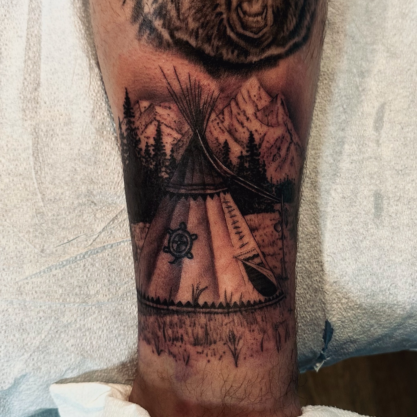 Teepee and landscape realism tattoo on the forearm by Arielle Deatherage