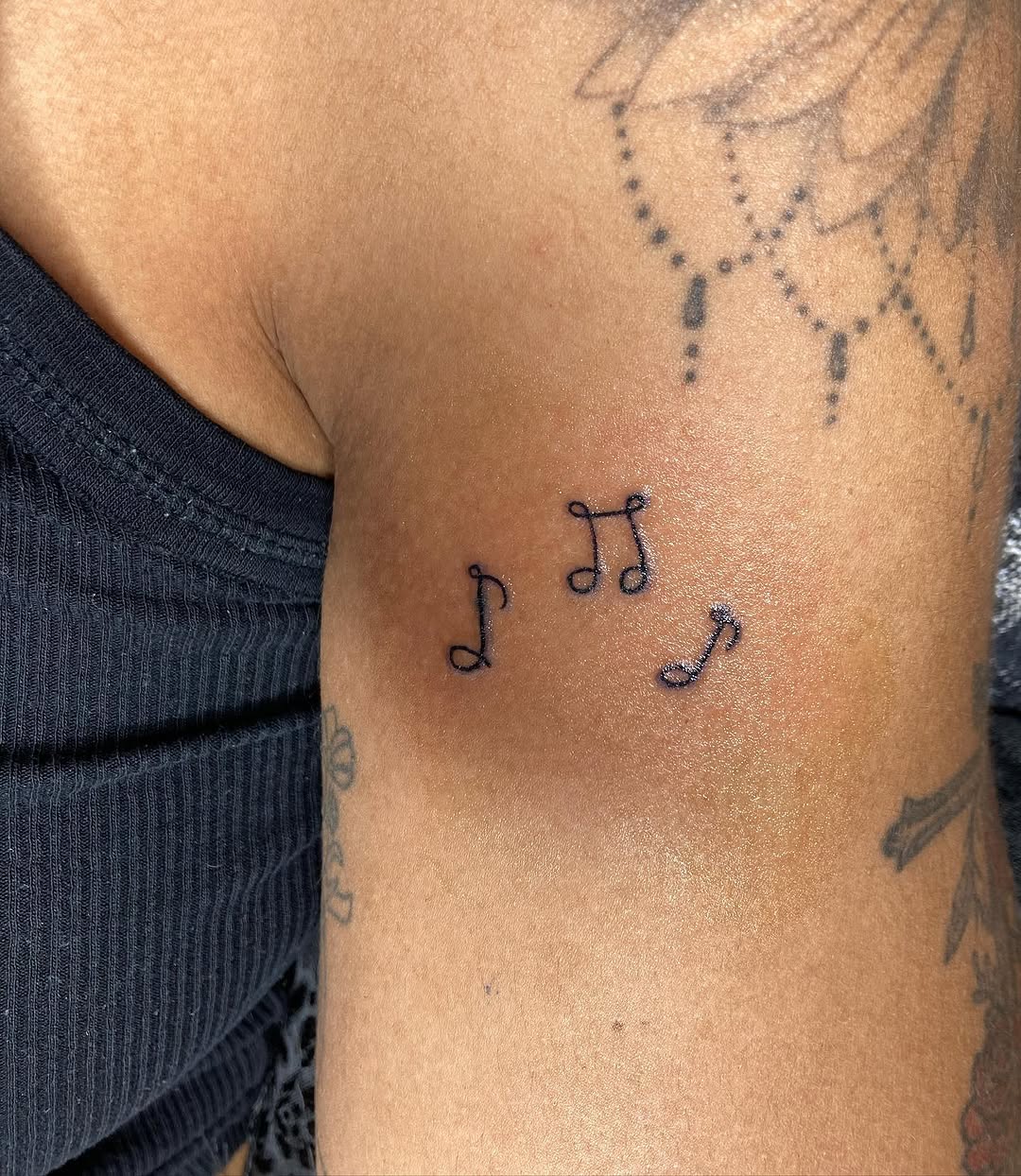 Musical notes minimalist tattoo on the upper arm by CmoreInk