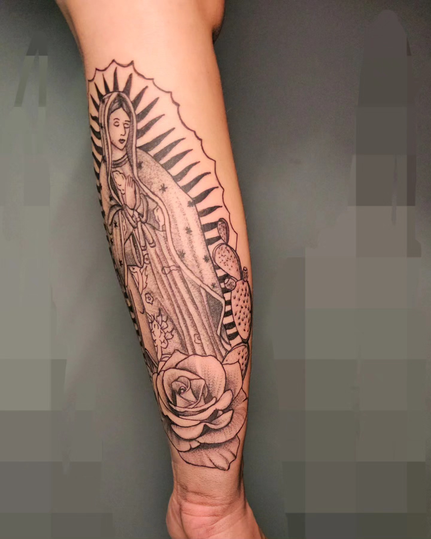 Our Lady of Guadalupe black and grey tattoo on the forearm by Eddy