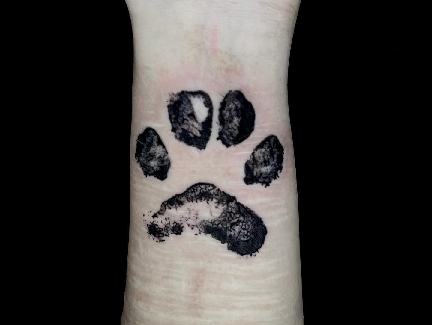 Paw print black and grey tattoo on the forearm by Angie Morales, Laredo, Texas