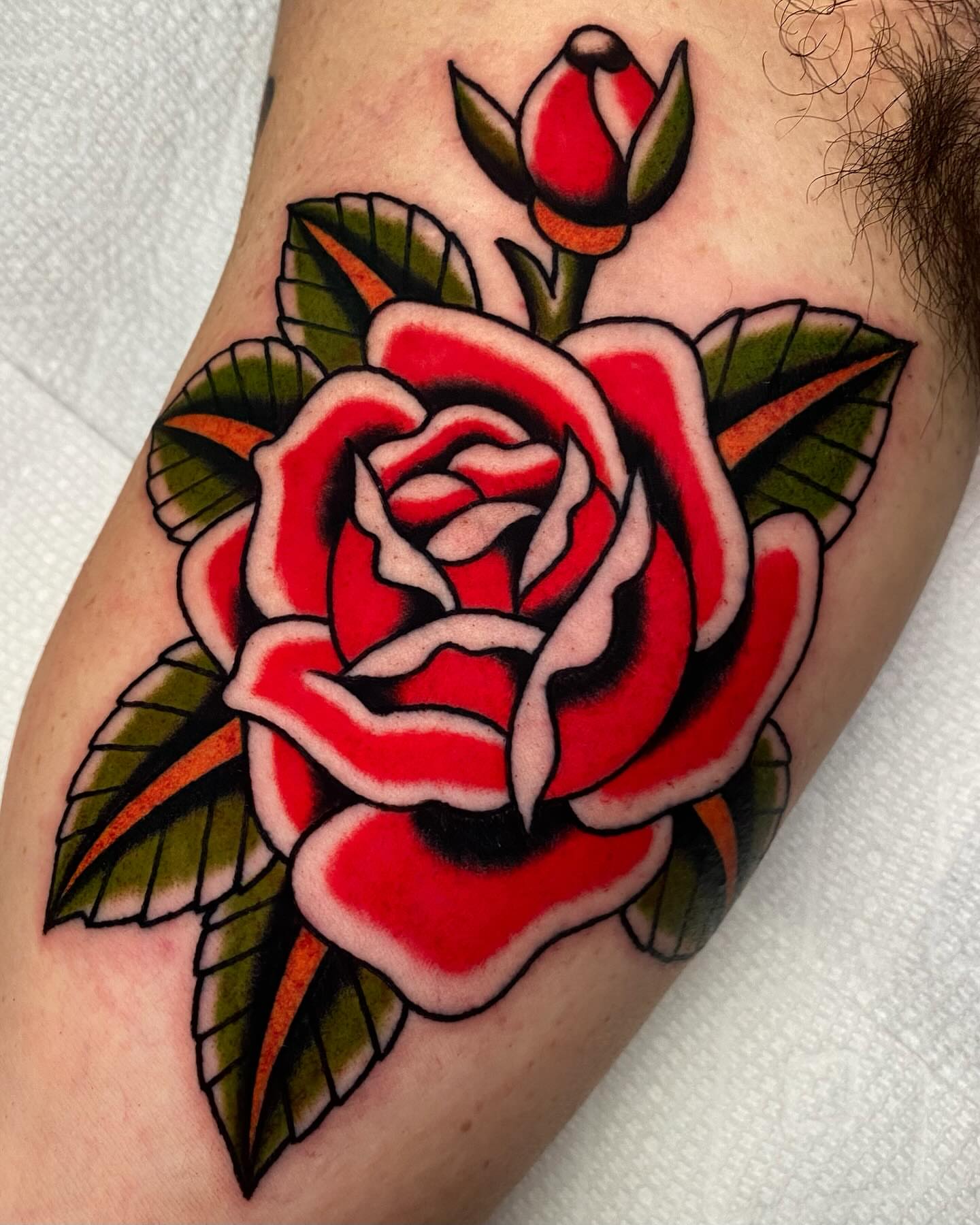Red rose American traditional tattoo on the forearm by Mitch Hoggard