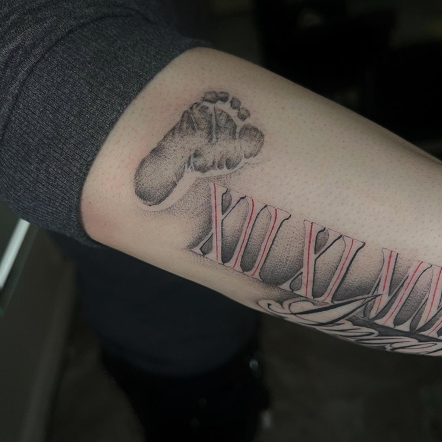 Footprint and Roman numerals dotwork tattoo on the forearm by Jocelyn