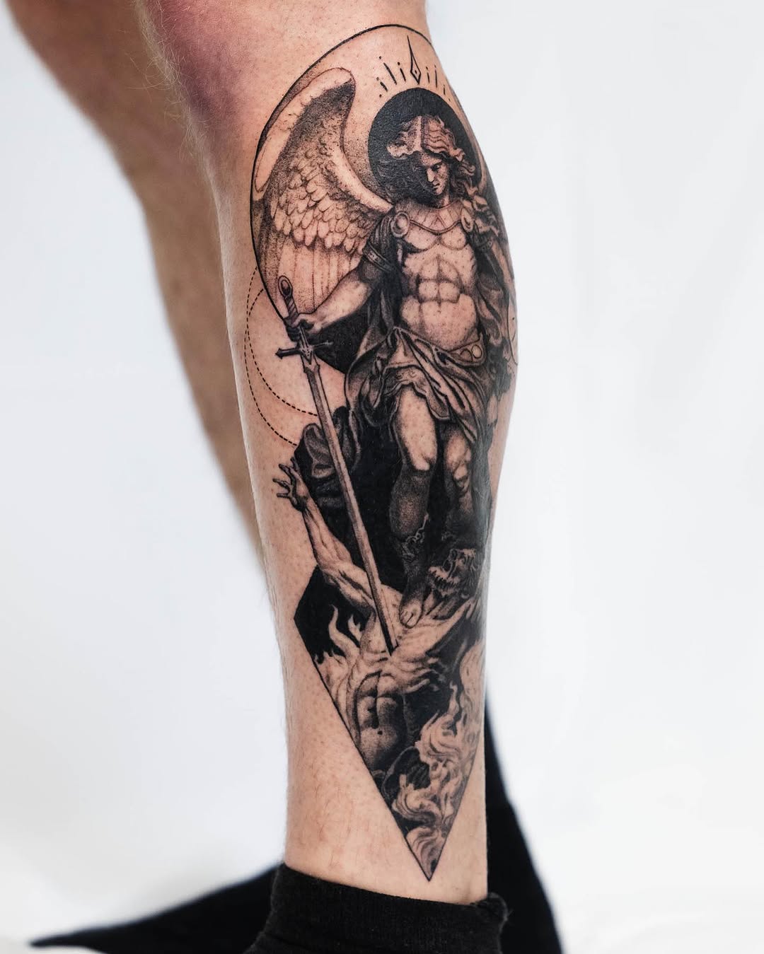 Archangel Michael slaying a demon realism tattoo on the calf by Ben Cisek