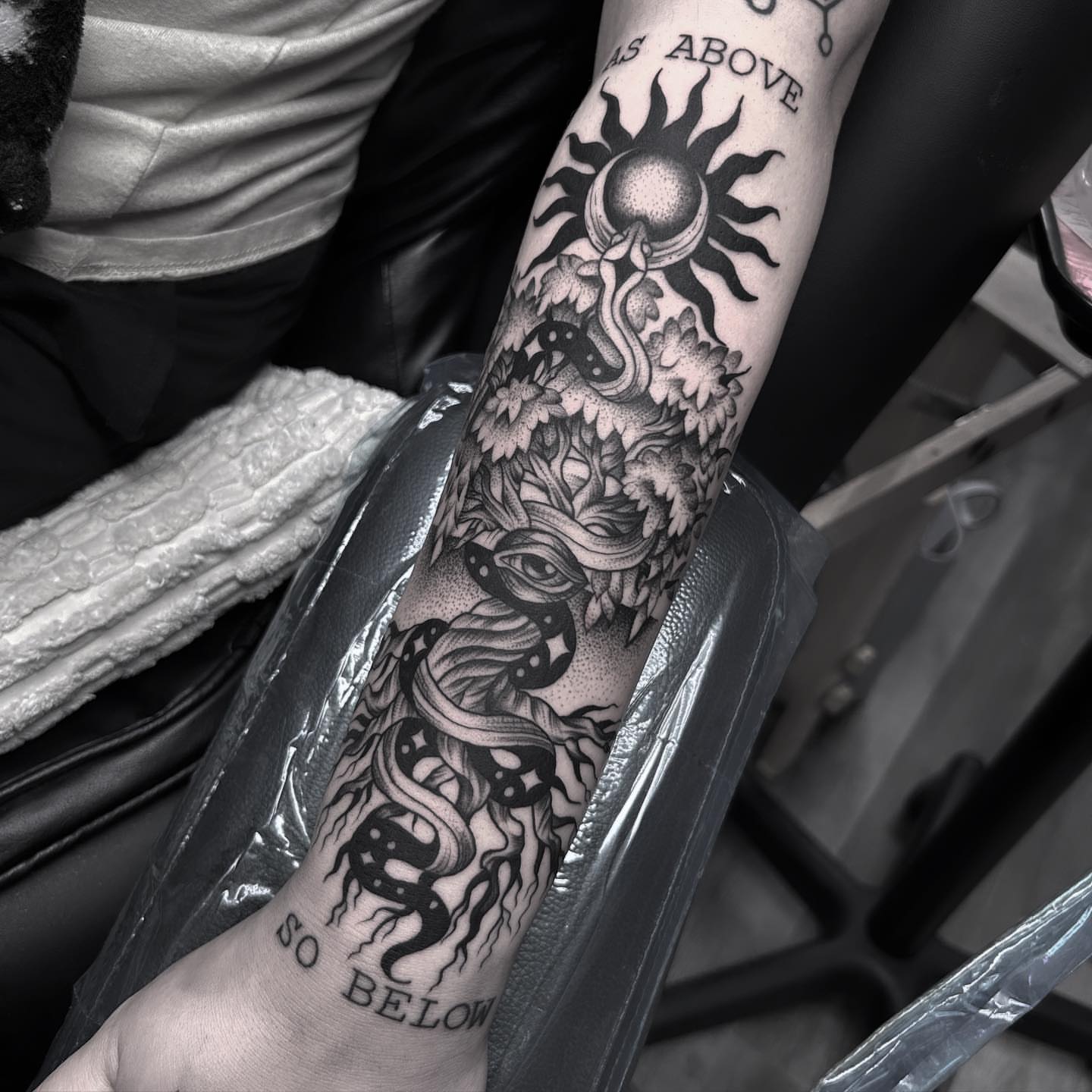 Snake and mask dotwork tattoo on the forearm by Anna Nicole Thomas