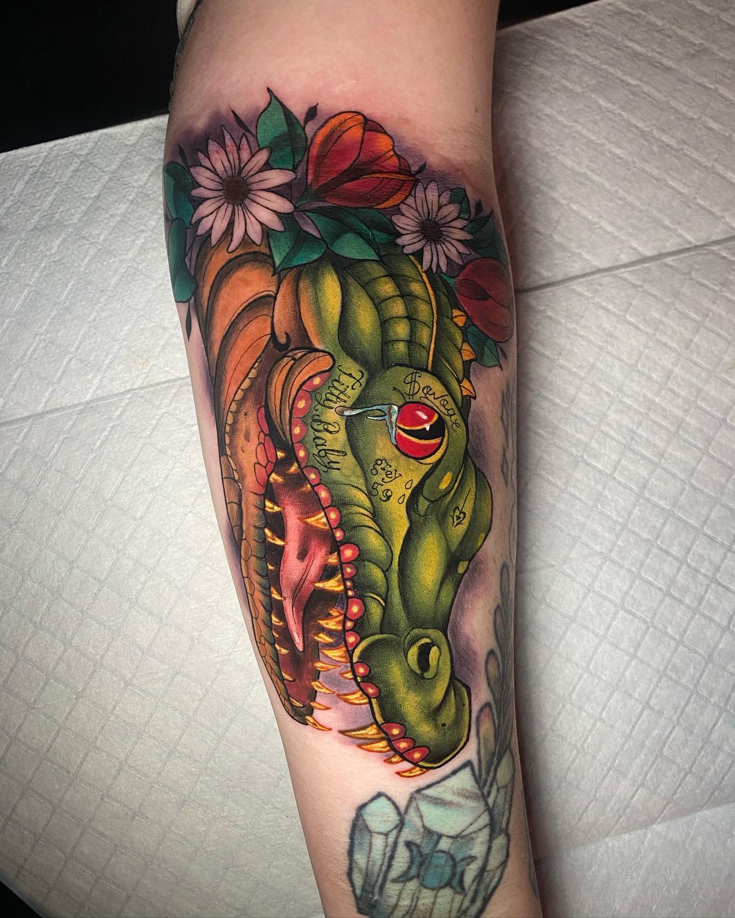 Dinosaur head American traditional tattoo on the forearm by Tattertot