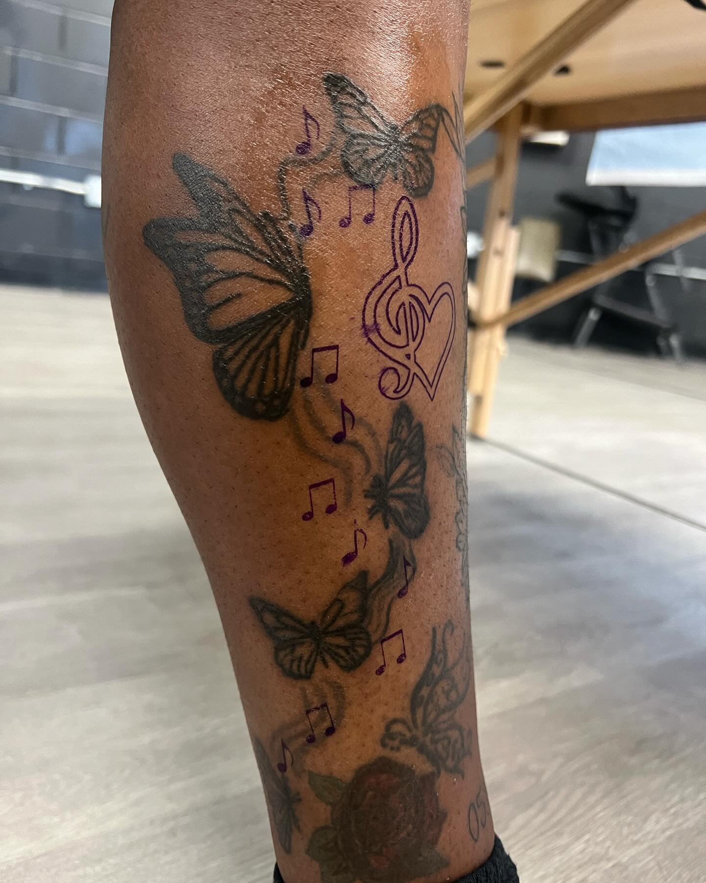 Butterflies and music notes black and grey tattoo on the forearm by Kai