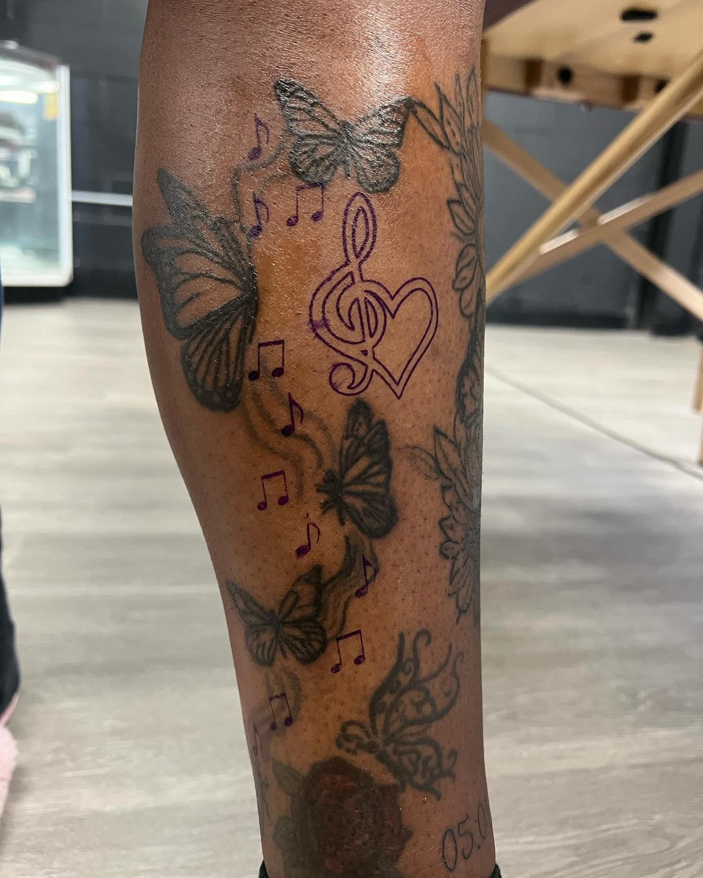 Butterflies and music notes black and grey tattoo on the forearm by Kai