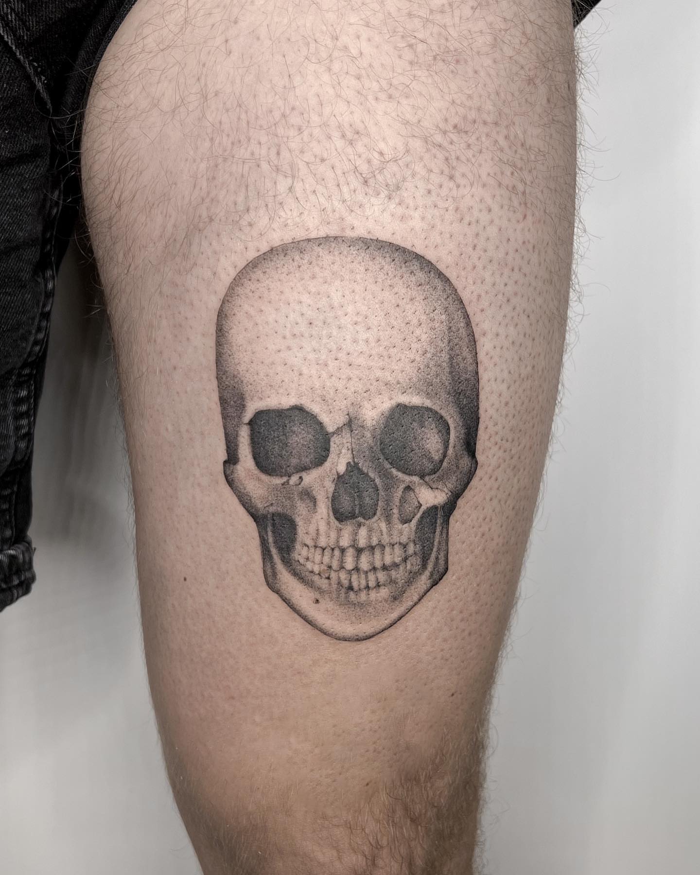 Skull dotwork tattoo on the thigh by Blackwork & microrealism tattoos