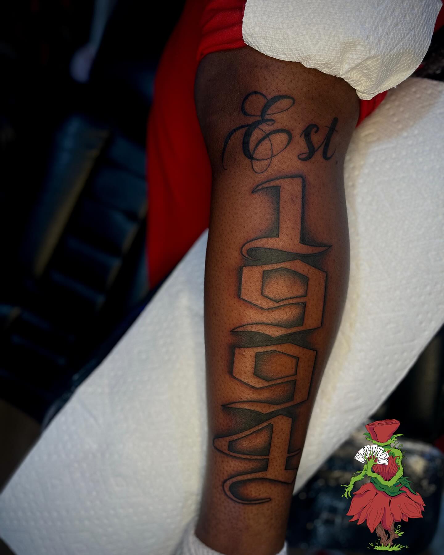 Establishment year lettering script tattoo on the forearm by Marques Neal