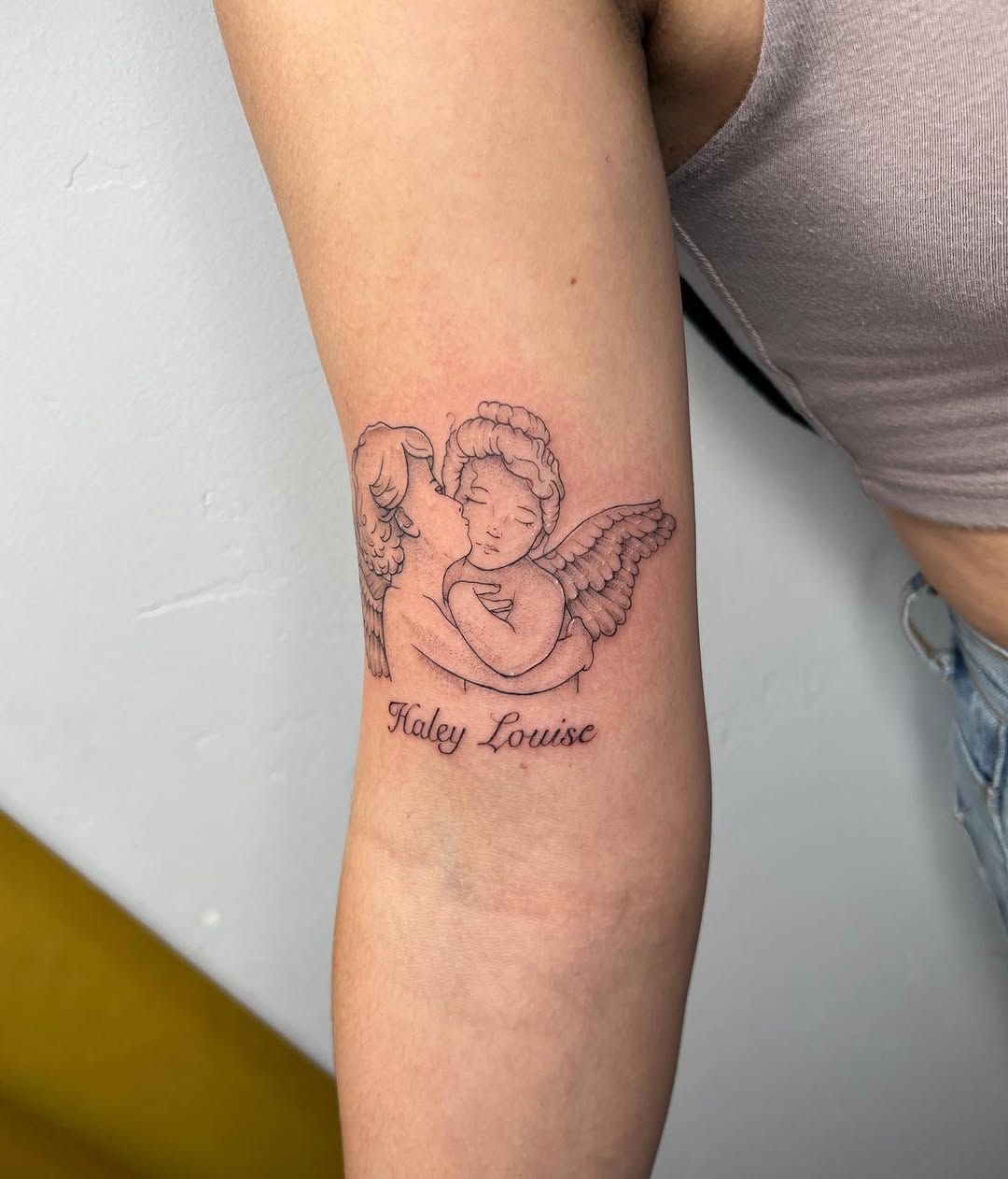 Cherubs embracing with name realism tattoo on the forearm by : *✧･ﾟ:* camryn  *:･ﾟ✧: