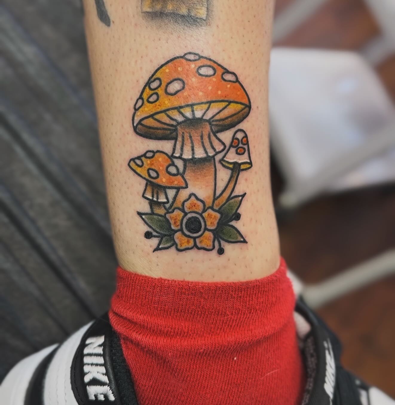 Mushroom and flowers American traditional tattoo on the forearm by Zach Eden
