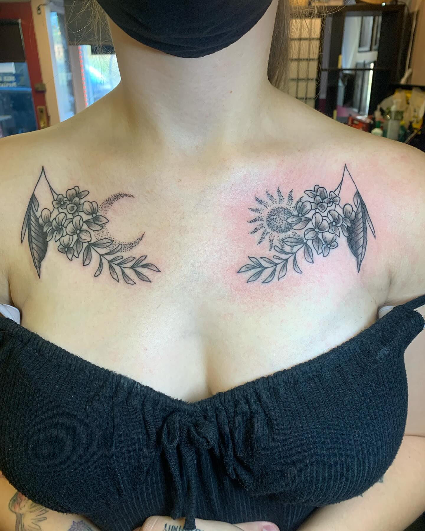 Floral crescent moon and sun black and grey tattoo on the chest by Cody Marl