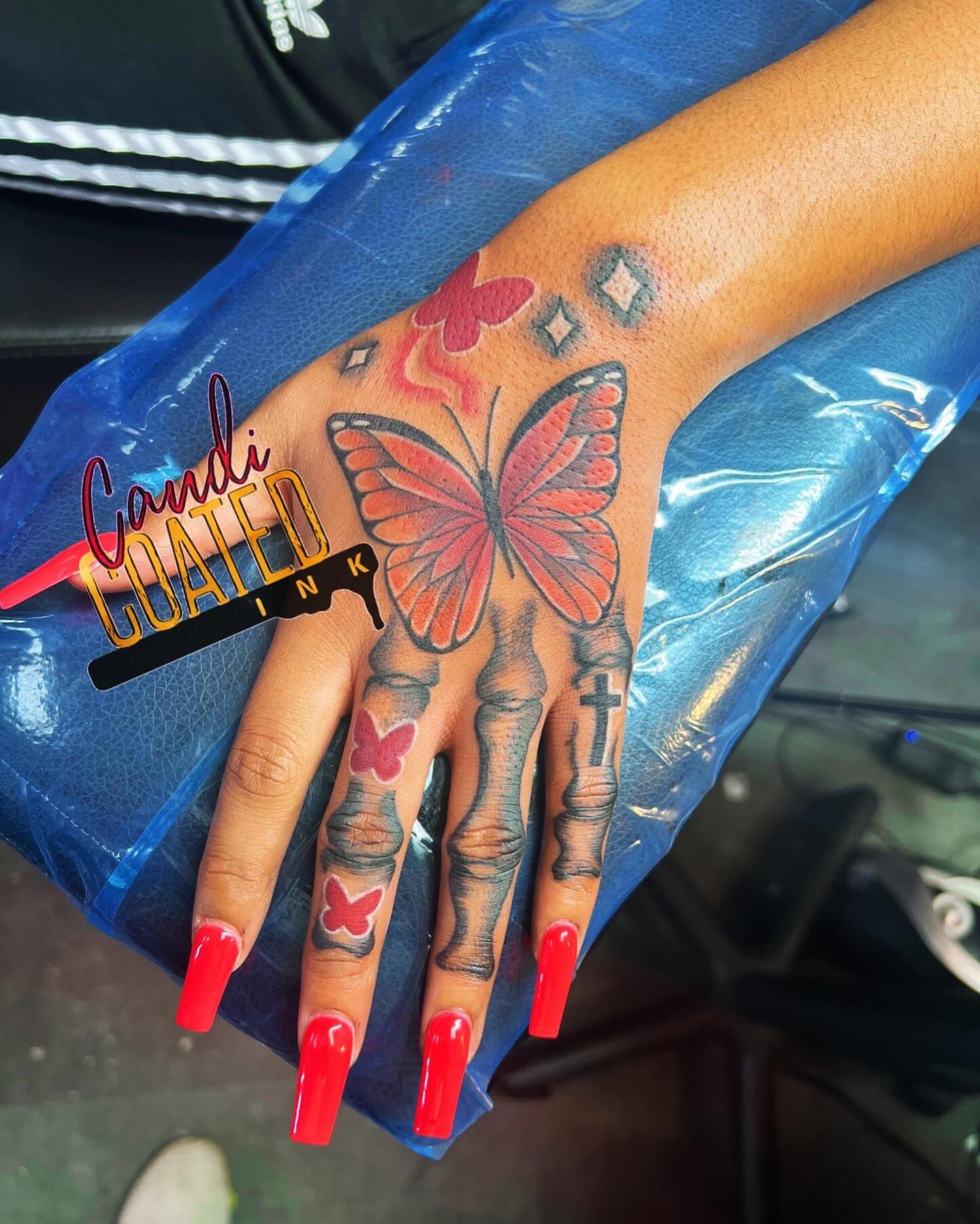 Butterfly skeleton hand American traditional tattoo on the hand by CandiCoatedInk