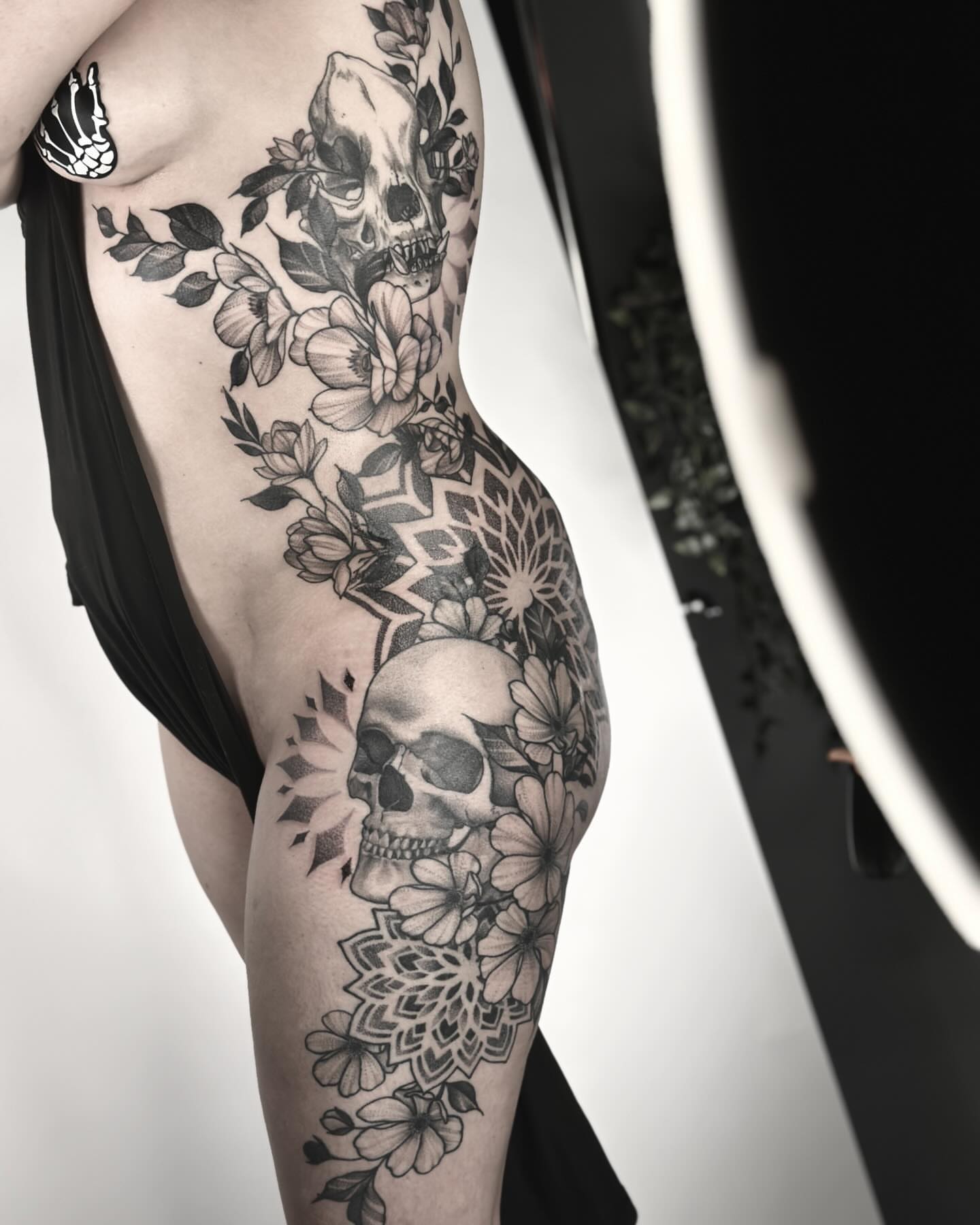 Skulls and flowers geometric tattoo on the thigh by Nick Fierro