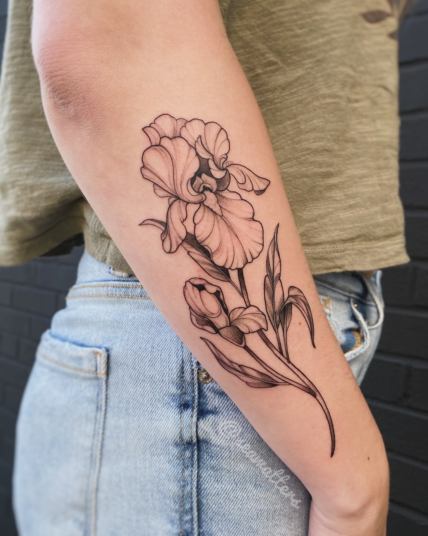 Iris bouquet black and grey tattoo on the forearm by Caitlin Watters