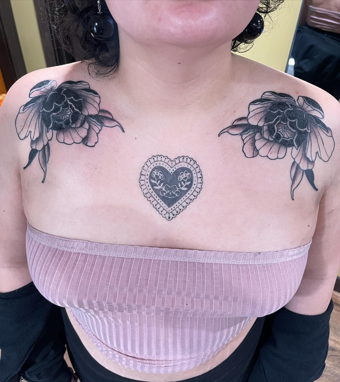 Heart with floral motifs black and grey tattoo on the chest by Minneapolis