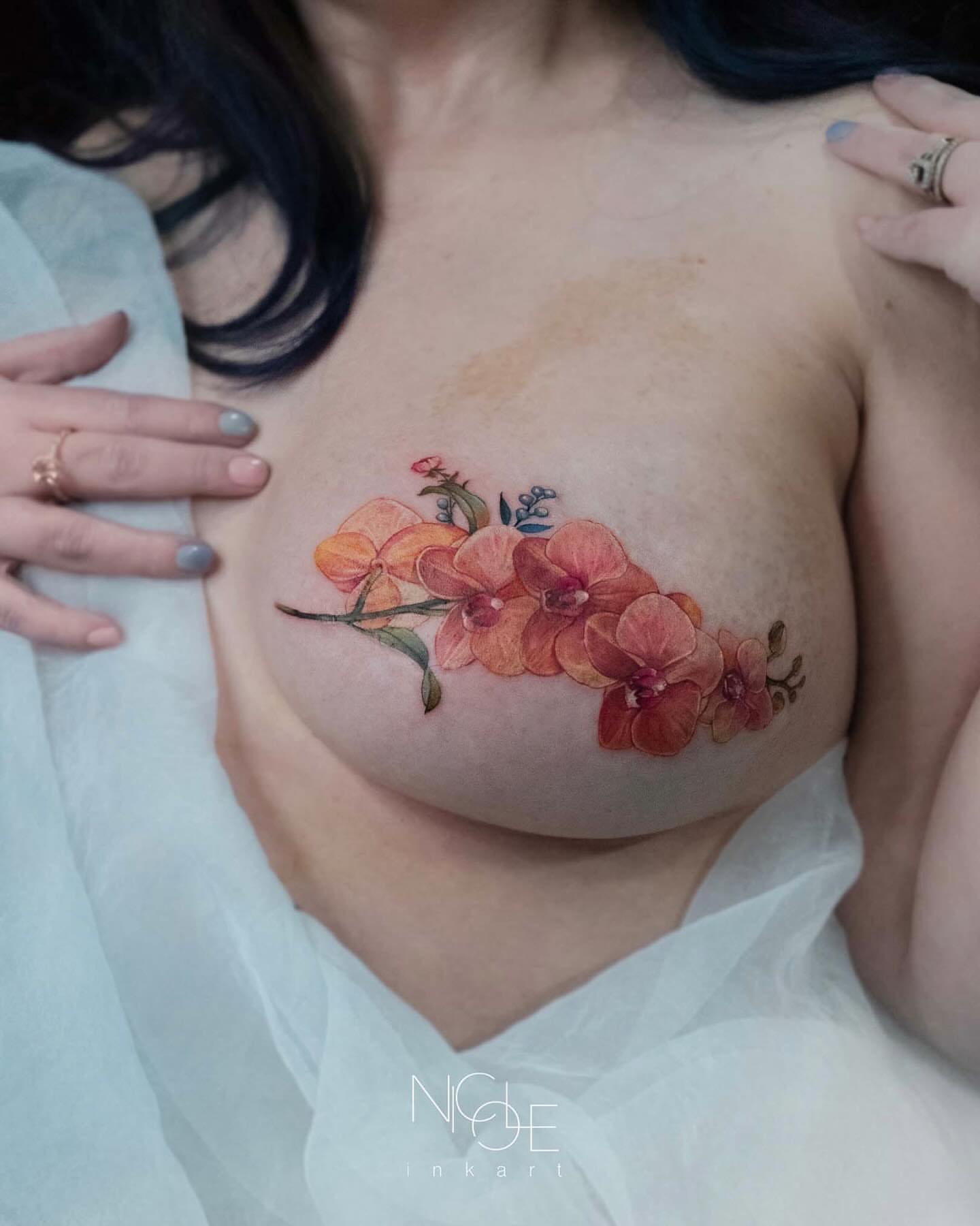 Orchids watercolor tattoo on the chest by 𝐍𝐈𝐂𝐎𝐋𝐄 𝐋