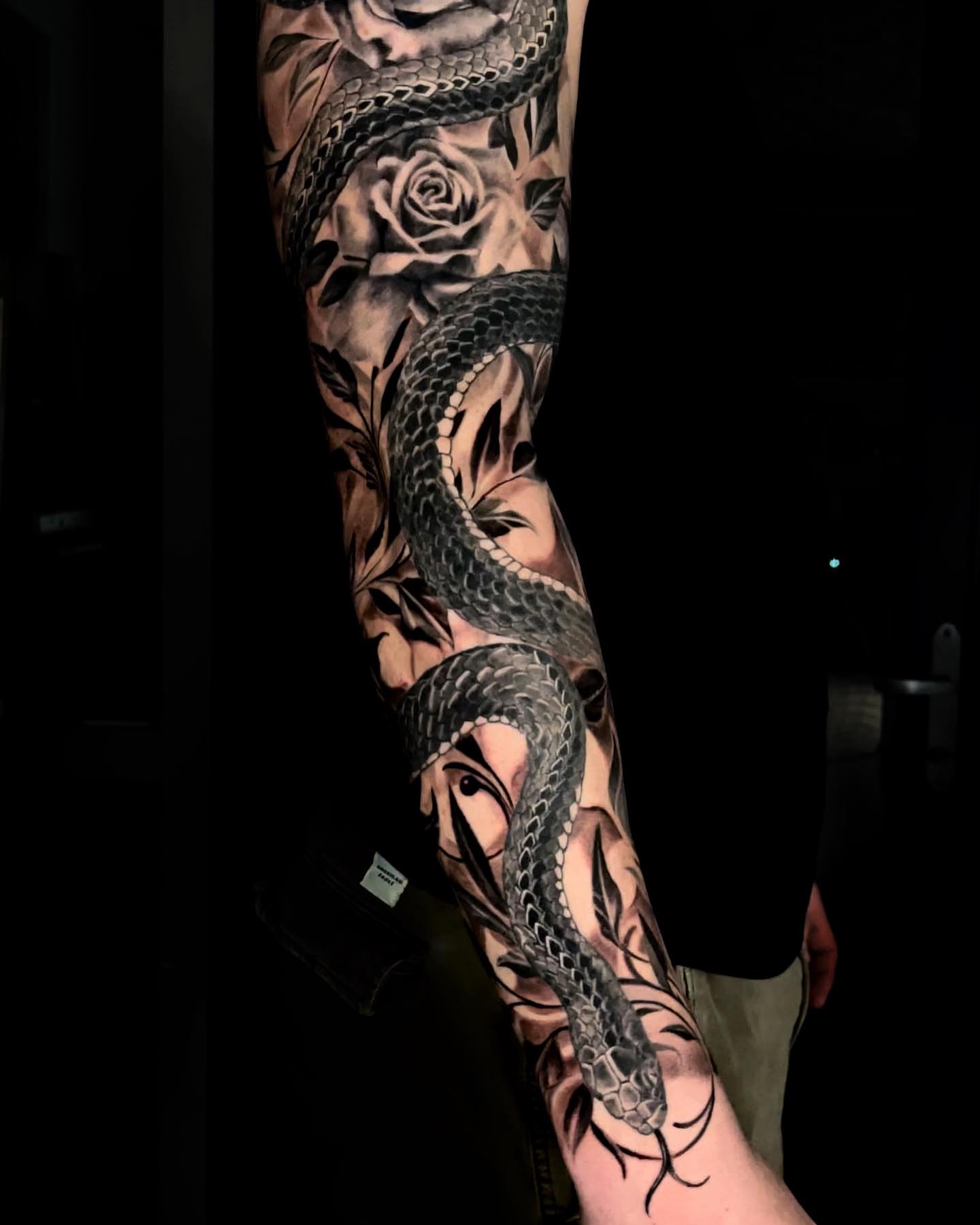 Snake and rose realism tattoo on the forearm by Tattoo Artist