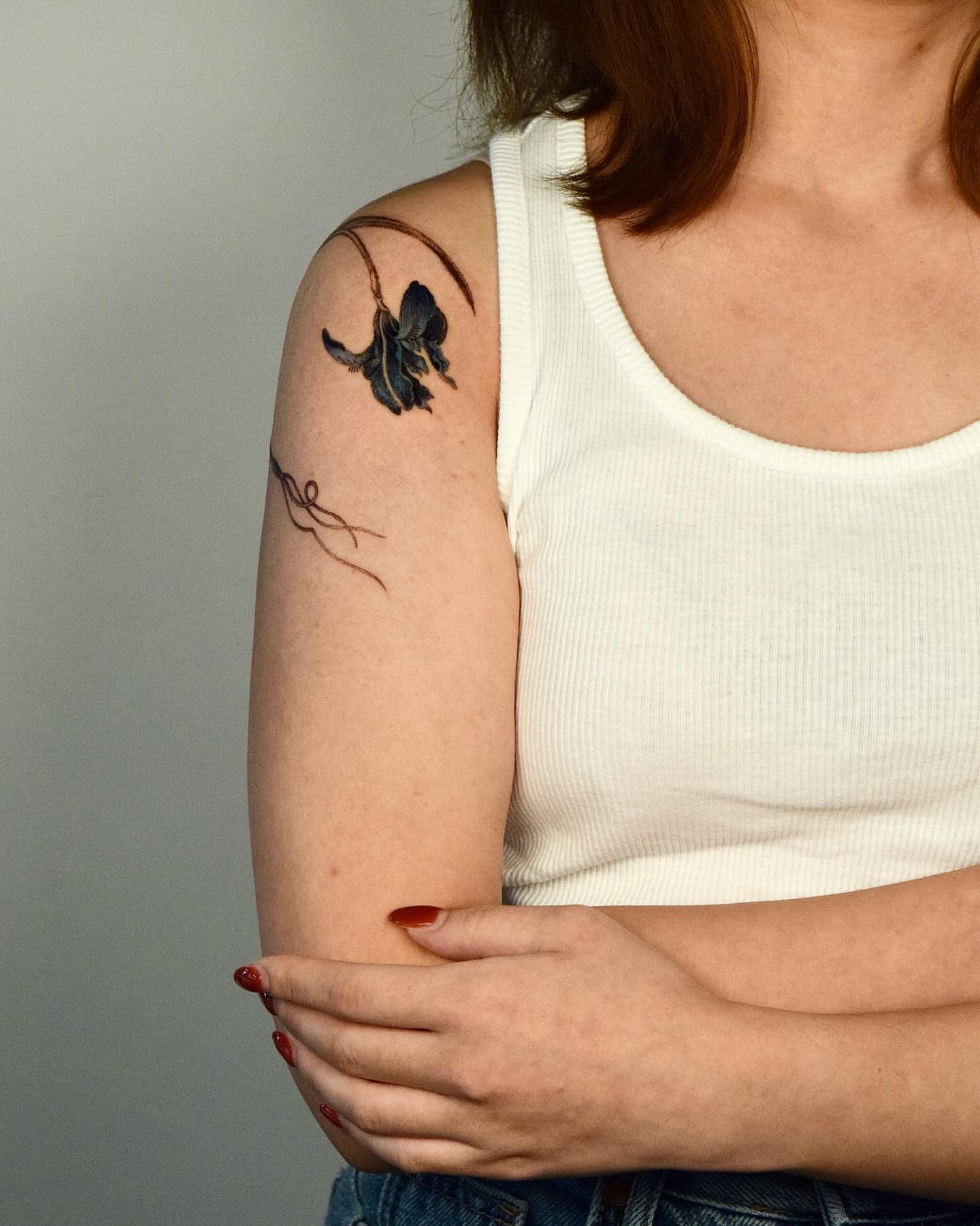 Butterfly watercolor tattoo on the upper arm by Stella Oh